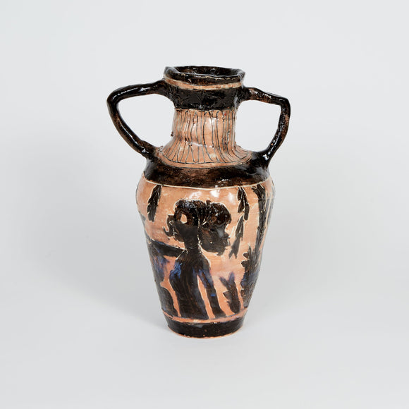 This ceramic vase, reminiscent of ancient Greek amphorae, features dual handles and is adorned with black-figure style imagery depicting silhouetted human and foliage motifs on a terracotta background. The contrast between the dark, expressive figures and the earthy clay body enhances the artifact's classical aesthetic, evoking themes of myth and antiquity.