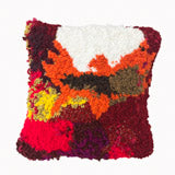 This textile piece features a densely tufted, abstract design with a vibrant color palette including shades of red, orange, yellow, and white, creating a visually dynamic and textured surface. The variation in yarn length and color blending adds depth and tactile richness, emphasizing the handcrafted quality and evoking a sense of organic movement within the composition.
