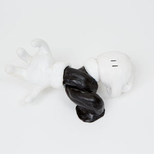 This ceramic sculpture resembles a disembodied, cartoon-style gloved hand and arm, twisted into a dynamic pose and rendered in high-contrast black and white. The simplified form and exaggerated proportions evoke classic animation aesthetics, capturing a sense of movement and whimsy that plays on familiar visual tropes.