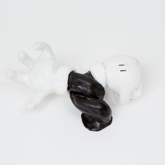 This ceramic sculpture resembles a disembodied, cartoon-style gloved hand and arm, twisted into a dynamic pose and rendered in high-contrast black and white. The simplified form and exaggerated proportions evoke classic animation aesthetics, capturing a sense of movement and whimsy that plays on familiar visual tropes.