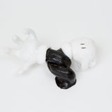This ceramic sculpture resembles a disembodied, cartoon-style gloved hand and arm, twisted into a dynamic pose and rendered in high-contrast black and white. The simplified form and exaggerated proportions evoke classic animation aesthetics, capturing a sense of movement and whimsy that plays on familiar visual tropes.