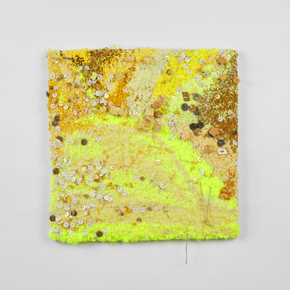 This is a twenty-three-inch square, punch-rug textile made by hand using a variety of textured yarn in different shades of yellow, ranging from bright neon hues to deeper golden shades. The highly textured work is interwoven with white and gold buttons as well as handmade, square ceramic charms that are carved with designs, such as little suns or the phrase “I love Tierra del Sol.” It is mounted on stretcher bars and hung on the wall.