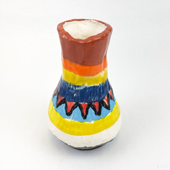 This ceramic vase features a bold, colorful design with horizontal bands of earthy brown, vibrant orange, yellow, and deep blue, accented by a jagged red and black pattern. The thick, glossy glaze enhances the vividness of the colors, giving the piece a lively, folk-art quality that celebrates geometric simplicity and rhythmic decoration.