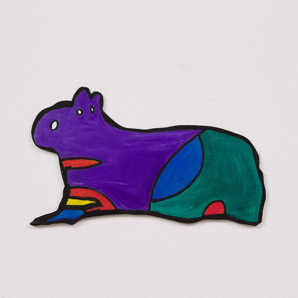 This 6 by 11 by 1/4th-inch wood sculpture by Hugo Rocha features a stylized, abstract animal—resembling a guinea pig or capybara—with a vibrant color scheme. The creature's front half is painted in bold purple, transitioning to blue and green at the rear. The legs are highlighted with orange, yellow, and blue stripes, adding more detail to the work.