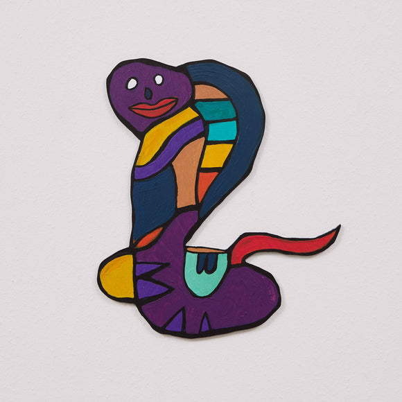 This 11 by 10 by 1/4th-inch wood sculpture by Hugo Rocha depicts a stylized, abstract cobra. The snake's body is painted in a variety of vibrant colors, including purple, orange, yellow, teal, and red, creating a striking, segmented appearance. The cobra's face has a simple, cartoon-like expression with white eyes and a red mouth.