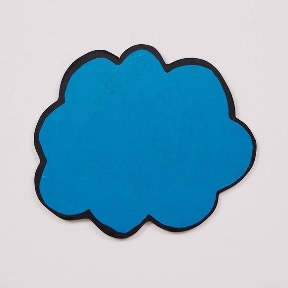 This 14 by 15 by 1/4th-inch wood sculpture by Hugo Rocha features a simple, abstract shape resembling a cloud. The sculpture is painted a solid, bright, cool blue with a thick black outline that defines its soft, rounded edges. The piece is minimalist, focusing on the bold use of color and shape to convey its form. The simplicity and vibrant hue enforce Rocha’s graphic style.