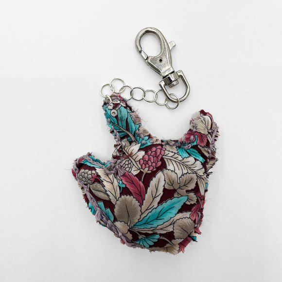 This work is one of three hand-made key-chains that say “I love you” in sign language. This key chain is embroidered with yellow thread and is made from green and purple tie-dyed fabric.
