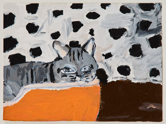 A grey striped cat rests on an orange cushion, surrounded by an abstract black-and-white spotted wall. The bold use of pattern and color gives this domestic scene a graphic punch.