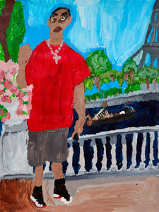 A man in a red shirt and gray shorts poses with a peace sign in a lush park with pink flowers and a glimpse of the Eiffel Tower in the distance.
