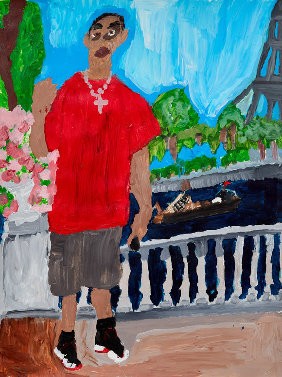A man in a red shirt and gray shorts poses with a peace sign in a lush park with pink flowers and a glimpse of the Eiffel Tower in the distance.