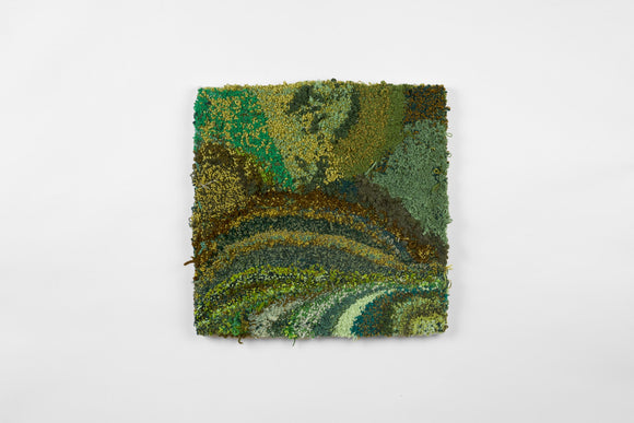 This is a twenty-three-inch square, punch-rug textile made by hand using a variety of textured yarn in various shades of green, ranging from dark olive and forest to light sea foam and teal. The different shades form patches and stripes, the highly textured work is mounted on stretcher bars and hung on the wall.