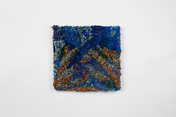 This is a seventeen-inch square, punch-rug textile made by hand using intuitively woven cotton yarn in a mix of deep blue, bright orange, dark green, and cool blue. The highly textured work is mounted on stretcher bars and hung on the wall. 