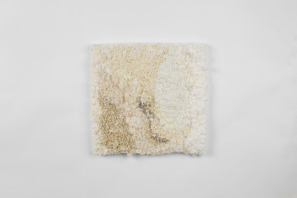 This is a nineteen-inch square, punch-rug textile made by hand using intuitively woven cotton yarn in a subtly modulating range of white and neutral shades. The soft, densely textured work is mounted on stretcher bars and hung on the wall. 
